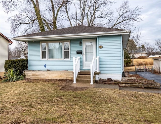 bungalow-style house featuring a front yard and roof with shingles