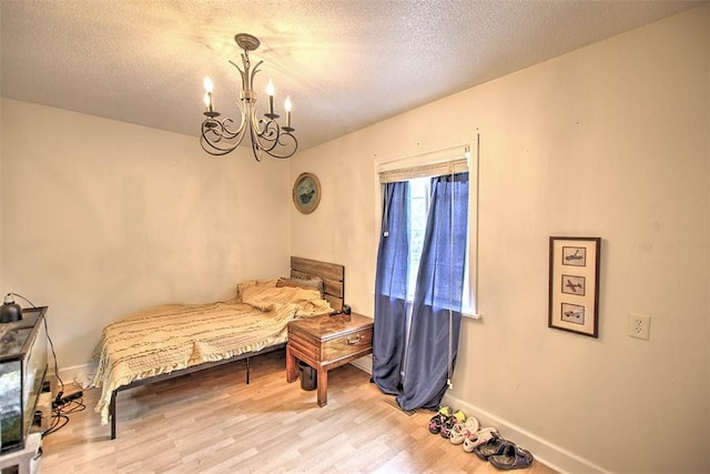 3985 E Cerro Gordo St, Decatur, IL 62521 - bedroom with a chandelier, wood finished floors, baseboards, and a textured ceiling