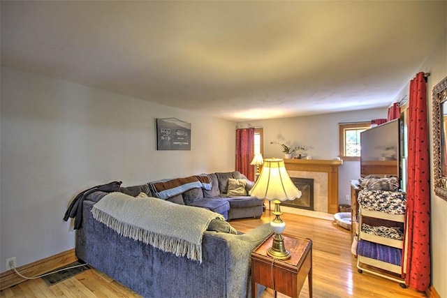 3985 E Cerro Gordo St, Decatur, IL 62521 - living area with light wood-style flooring, a tile fireplace, and baseboards