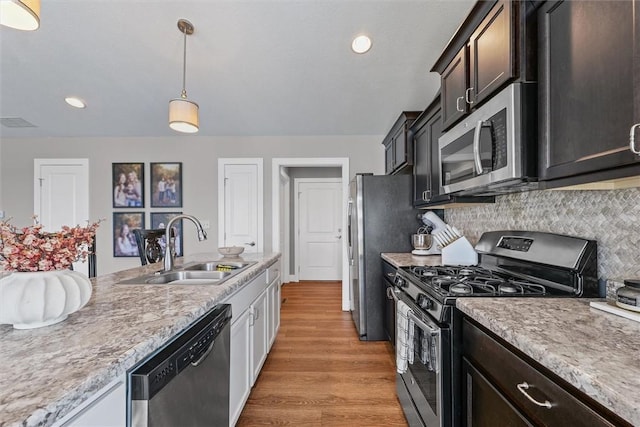 1121 Meadow Brook Ct, Mattoon, IL 61938 - kitchen with appliances with stainless steel finishes, light wood finished floors, light countertops, tasteful backsplash, and decorative light fixtures