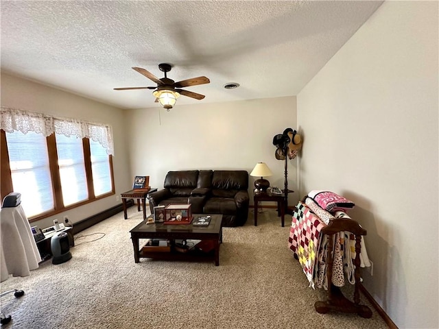 living room with a textured ceiling, carpet flooring, and ceiling fan