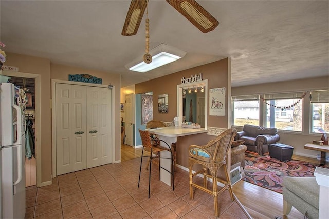 dining room featuring light tile patterned flooring, ceiling fan, and baseboards