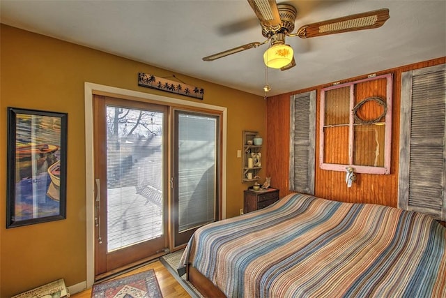 bedroom with access to exterior, light wood-type flooring, and a ceiling fan