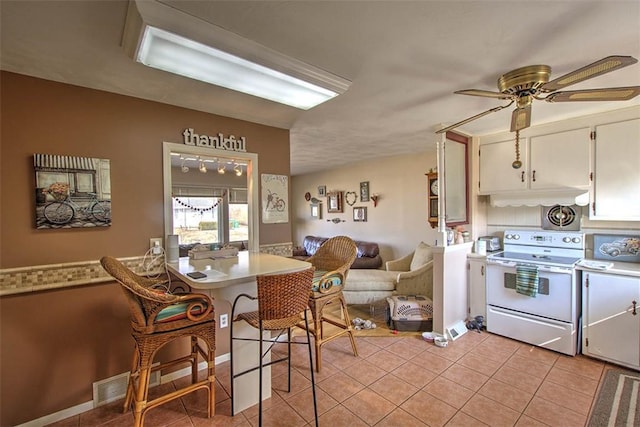 dining room featuring ceiling fan, light tile patterned flooring, and visible vents