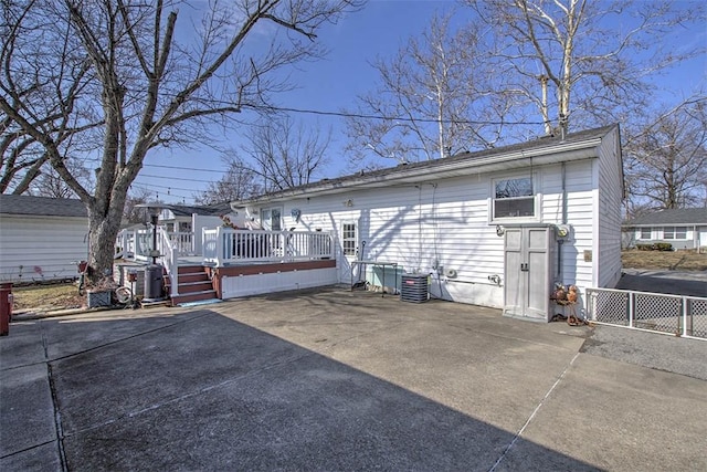 back of property with cooling unit, a patio area, fence, and a deck