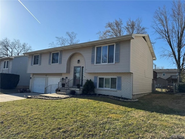 raised ranch featuring brick siding, concrete driveway, a front lawn, and fence