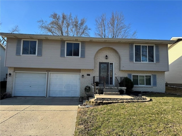 raised ranch with brick siding, driveway, an attached garage, and a front yard