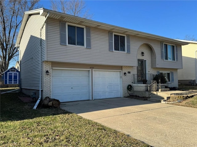 raised ranch with brick siding, an attached garage, and driveway