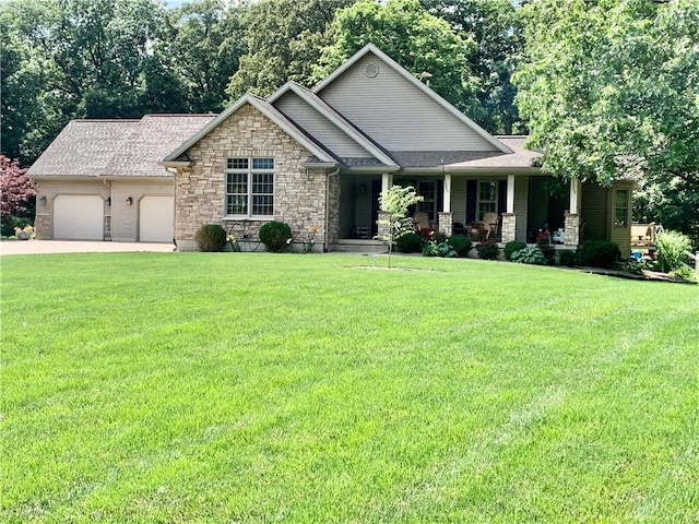 15690 E 1100th Ave, Effingham, IL 62401 - view of front of house with an attached garage, stone siding, concrete driveway, covered porch, and a front yard