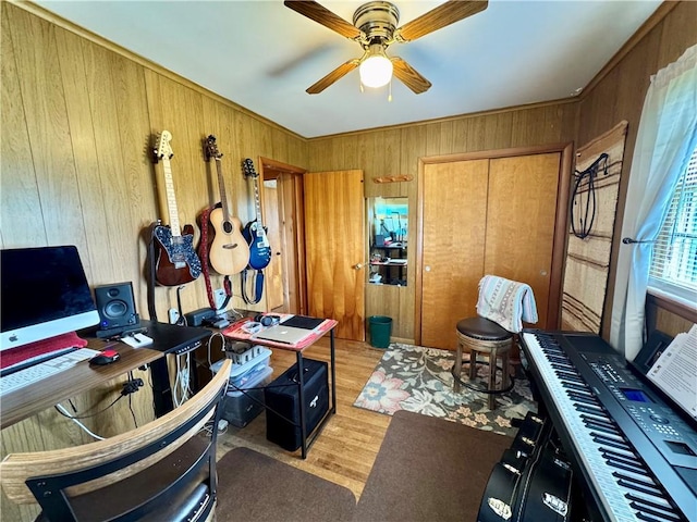 office area featuring wooden walls, ceiling fan, and wood finished floors