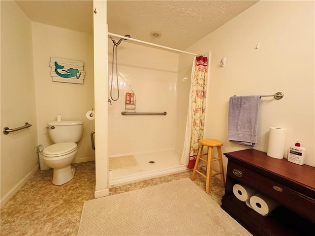 bathroom featuring toilet, a stall shower, baseboards, and a textured ceiling