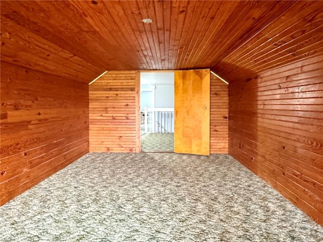 additional living space with wood walls, lofted ceiling, carpet, and wood ceiling