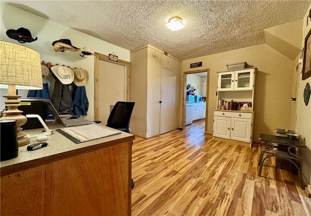 home office featuring light wood-style flooring and a textured ceiling