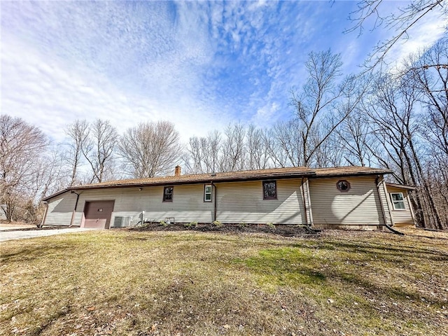 single story home with a front yard, cooling unit, and a garage