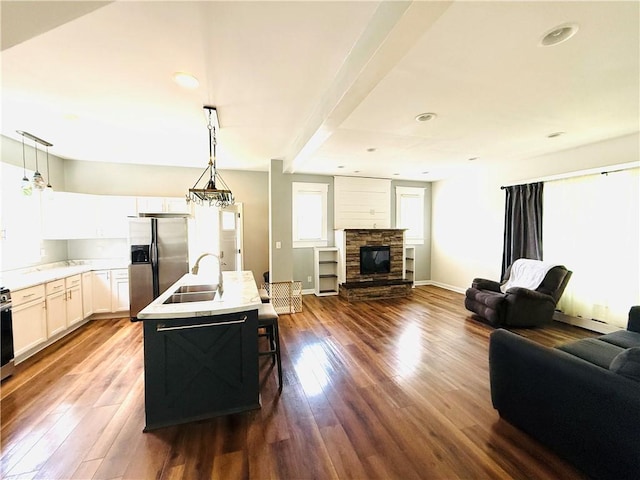 403 S 2nd Ave, Hoopeston, IL 60942 - kitchen with stainless steel appliances, open floor plan, a sink, dark wood-style floors, and hanging light fixtures