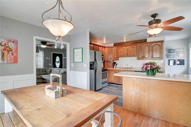 530 Sunset Dr, Mt Zion, IL 62549 - dining room featuring a ceiling fan, wainscoting, light wood-type flooring, and a decorative wall