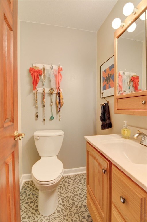 530 Sunset Dr, Mt Zion, IL 62549 - half bath featuring baseboards, vanity, toilet, and tile patterned flooring