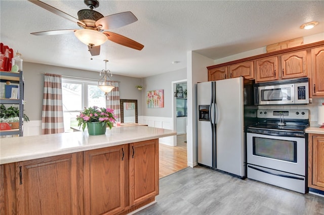 530 Sunset Dr, Mt Zion, IL 62549 - kitchen with stainless steel appliances, a textured ceiling, light wood-style flooring, light countertops, and brown cabinetry
