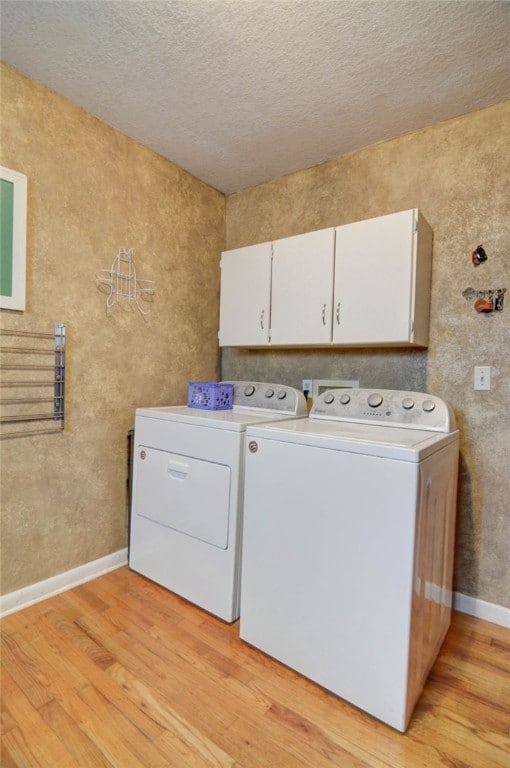530 Sunset Dr, Mt Zion, IL 62549 - laundry room with cabinet space, washer and dryer, light wood finished floors, baseboards, and a textured ceiling