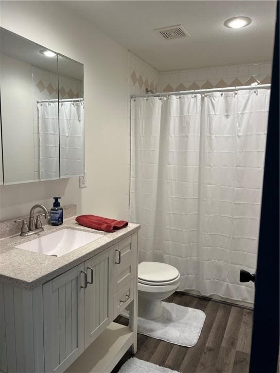 bathroom with vanity, toilet, curtained shower, and hardwood / wood-style floors