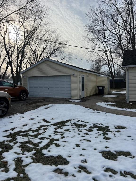 snow covered property with an outbuilding and a garage