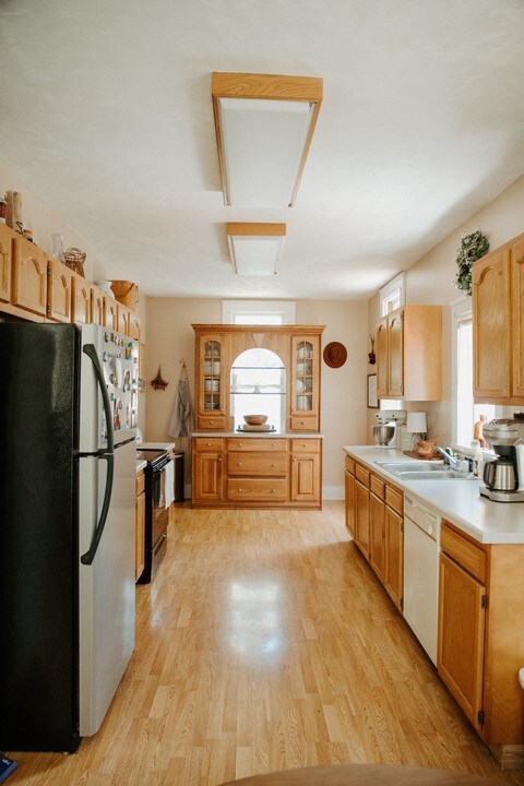 403 Maple St, Marshall, IL 62441 - kitchen featuring freestanding refrigerator, black electric range oven, dishwasher, glass insert cabinets, and light countertops