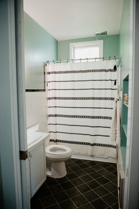 403 Maple St, Marshall, IL 62441 - full bathroom with vanity, tile walls, tile patterned floors, a wainscoted wall, and a shower with shower curtain