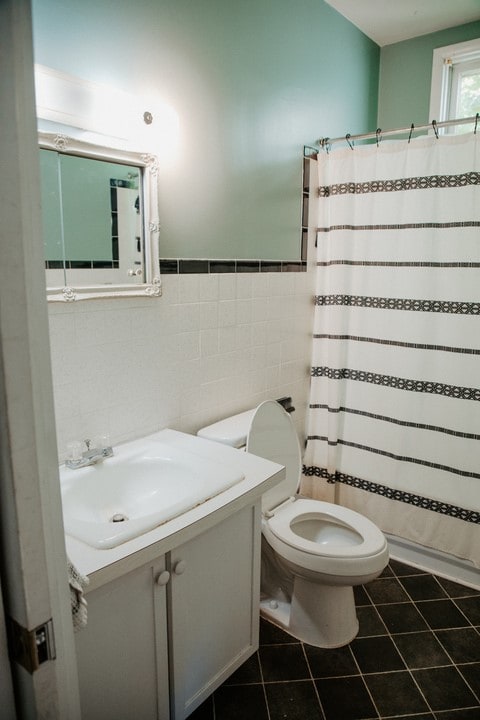 403 Maple St, Marshall, IL 62441 - bathroom with tile walls, vanity, tile patterned flooring, a shower with shower curtain, and a wainscoted wall