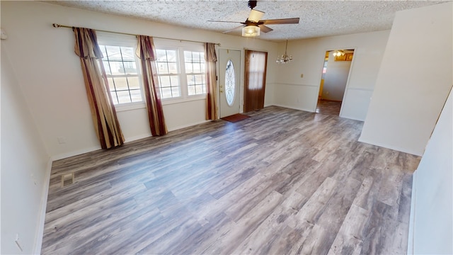 interior space with ceiling fan, a textured ceiling, and light wood-type flooring