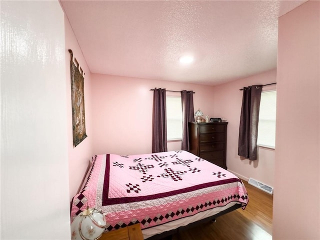 106 N Jefferson St, Greenup, IL 62428 - bedroom with a textured ceiling, wood finished floors, and baseboards