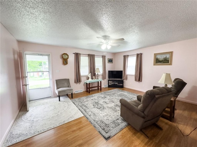 106 N Jefferson St, Greenup, IL 62428 - living area with ceiling fan, baseboards, wood finished floors, and a textured ceiling