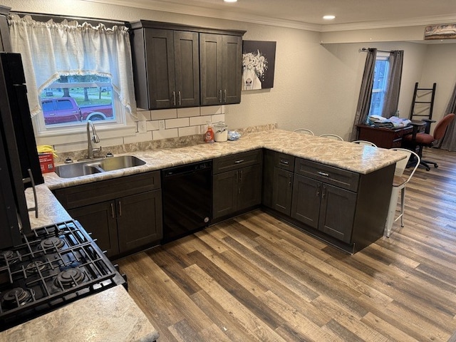 303 E Glenwood Ave, Olney, IL 62450 - kitchen featuring dishwasher, a sink, crown molding, wood finished floors, and a peninsula