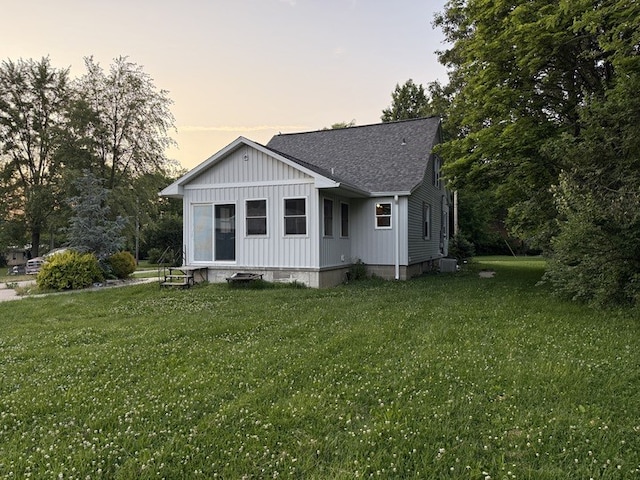 303 E Glenwood Ave, Olney, IL 62450 - view of front of home featuring a shingled roof, a lawn, and board and batten siding