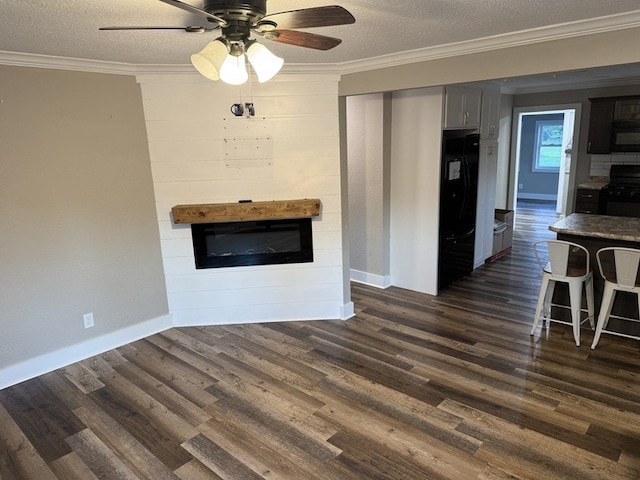 303 E Glenwood Ave, Olney, IL 62450 - unfurnished living room with ornamental molding, a glass covered fireplace, dark wood finished floors, a textured ceiling, and a ceiling fan