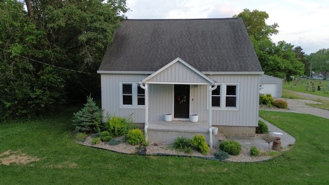 303 E Glenwood Ave, Olney, IL 62450 - view of front of property with a front yard, roof with shingles, and covered porch