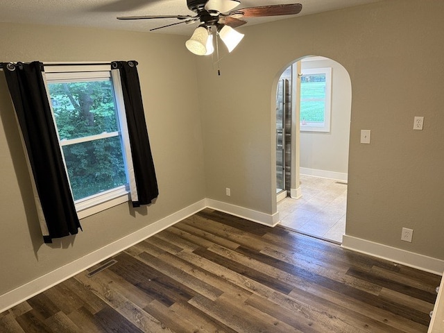 303 E Glenwood Ave, Olney, IL 62450 - spare room with arched walkways, a ceiling fan, plenty of natural light, and wood finished floors