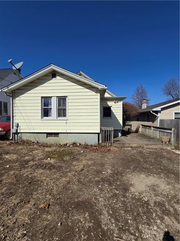 view of side of property featuring a deck and fence