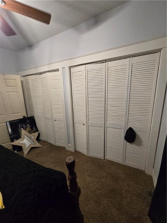 bedroom with carpet floors, a ceiling fan, and multiple closets