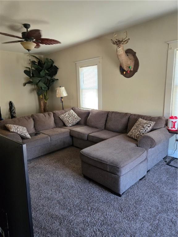 carpeted living room with ceiling fan