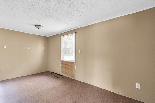 carpeted empty room featuring a textured ceiling