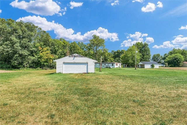 view of yard with an outdoor structure and a detached garage