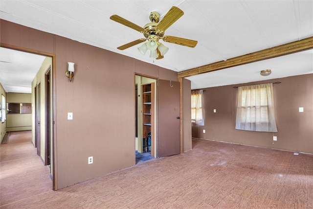 spare room with ceiling fan, baseboard heating, and beamed ceiling