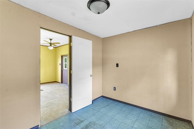 spare room featuring light floors and baseboards