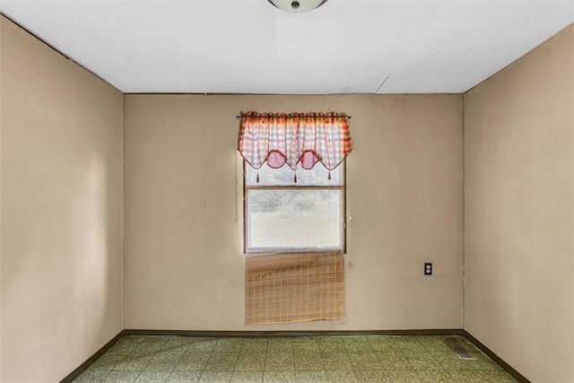 unfurnished room with baseboards and tile patterned floors