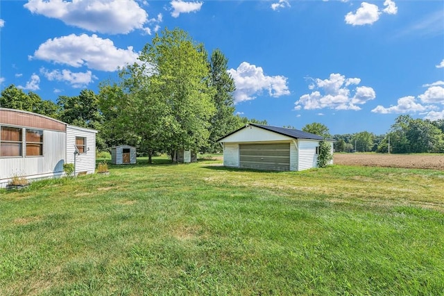 view of yard featuring a garage and an outbuilding