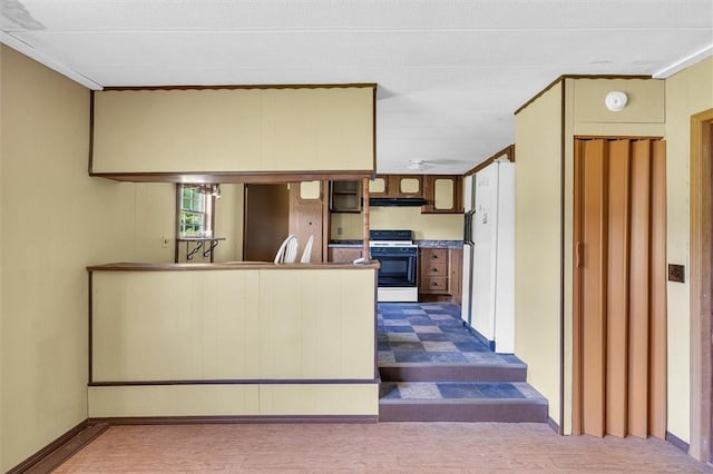 kitchen featuring exhaust hood, a peninsula, and gas range