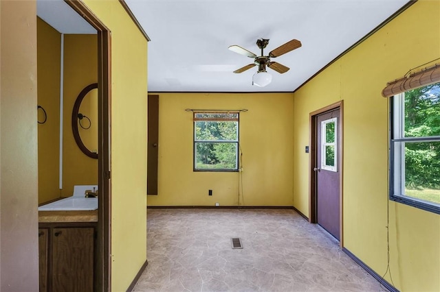 unfurnished room with a ceiling fan, visible vents, and a sink