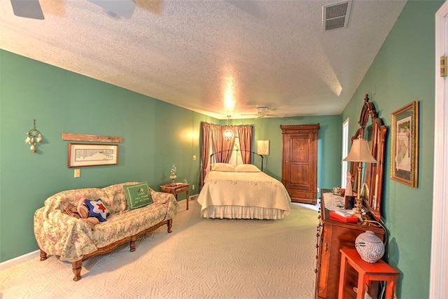 bedroom with ceiling fan, carpet, and a textured ceiling