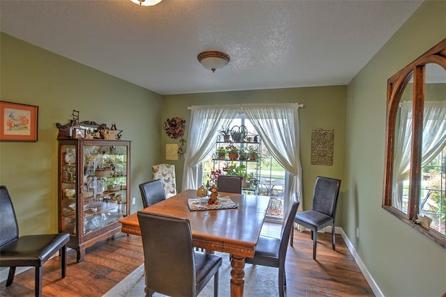 dining area with dark hardwood / wood-style flooring and a textured ceiling