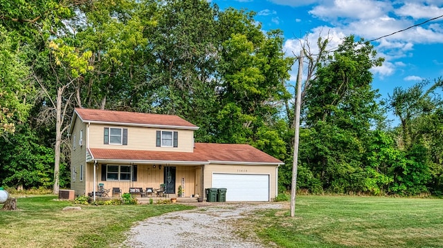 view of front of home featuring covered porch, a front yard, and a garage